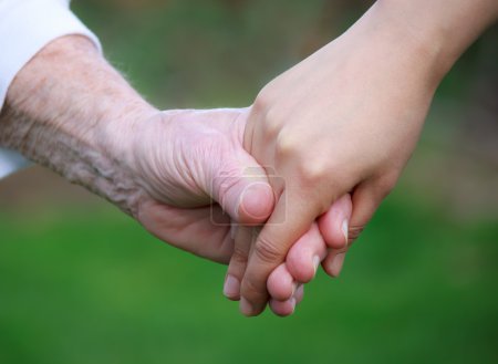 Young holding senior's hand