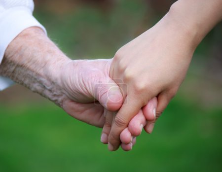 Young holding senior's hand