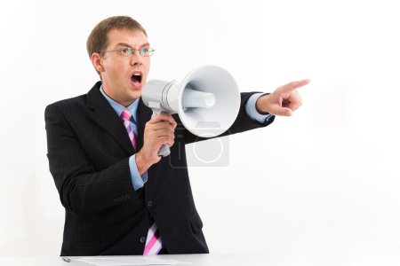 Unhappy man in suit speaking through megaphone and pointing aside