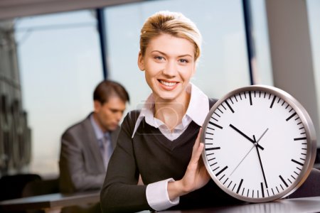 Portrait of responsible woman with watch in the office