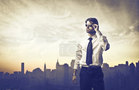 Portrait of a young businessman with skyline of a big city in the background
