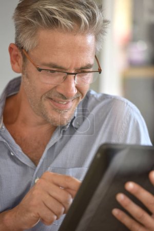  mature man using digital tablet