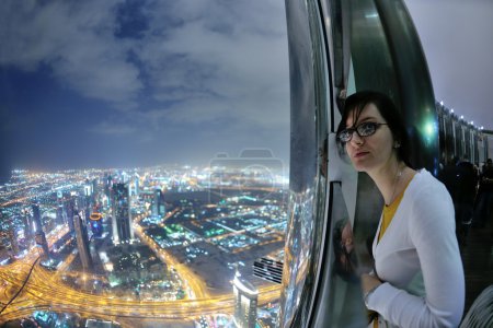 Beautiful woman portrait with big city at night in background