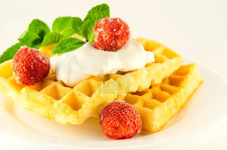 Wafers with a strawberry, cream and mint, a tasty dessert