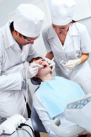 Image of doctor healing patient's teeth