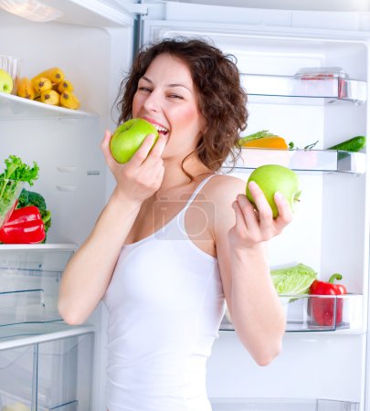 Beautiful Young Woman near the Refrigerator with healthy food