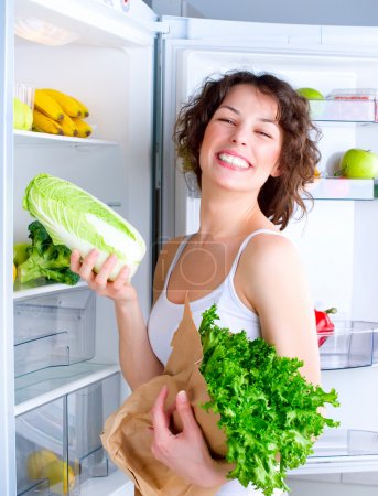 Beautiful Young Woman near the Refrigerator with healthy food