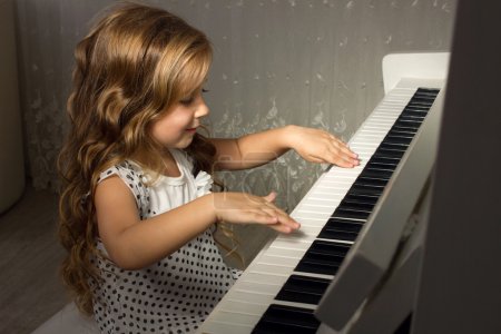 Blond girl playing a piano